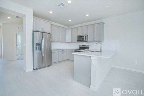 A modern kitchen with white cabinets and a stainless steel refrigerator.
