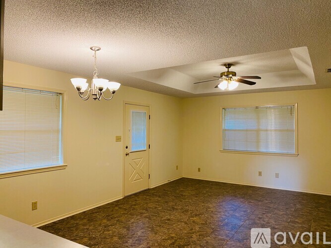 A room with a ceiling fan and a chandelier.
