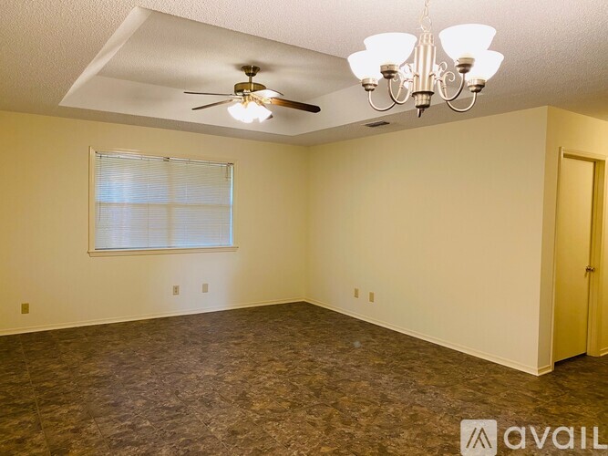 A room with a ceiling fan and a chandelier.
