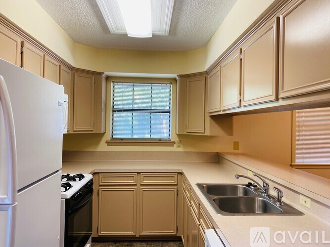 A kitchen with wooden cabinets and a white refrigerator.