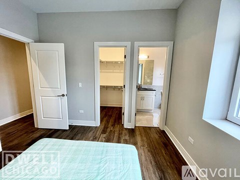 A bedroom with a bed in the foreground and a doorway leading to another room.