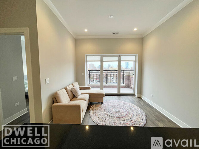 A living room with a couch and a rug in front of a sliding glass door.