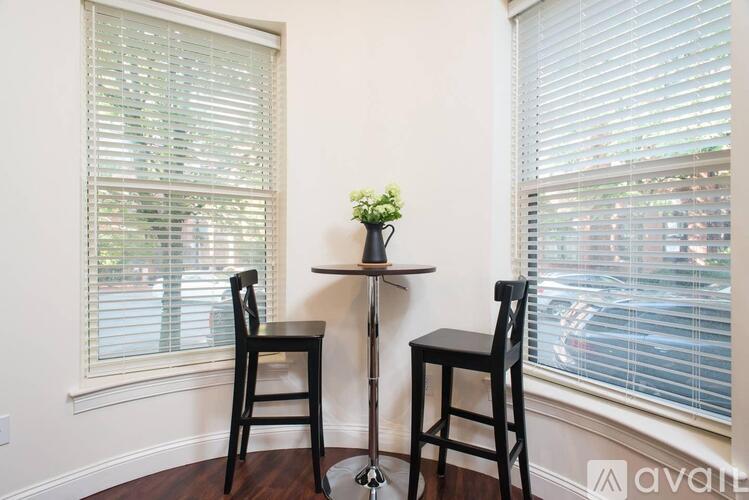 Two chairs and a small table with flowers on it.