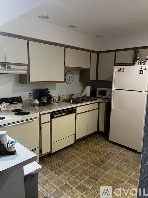 A kitchen with a white refrigerator, white oven, and white cabinets.