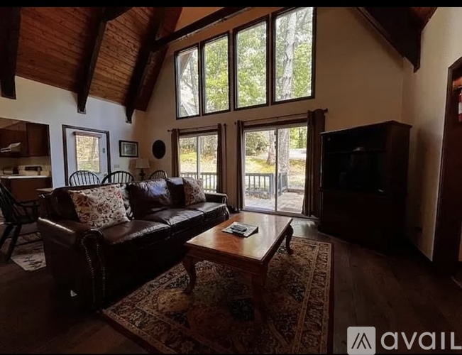 A living room with a brown leather couch and a wooden coffee table.