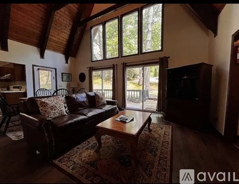 A living room with a brown leather couch and a wooden coffee table.