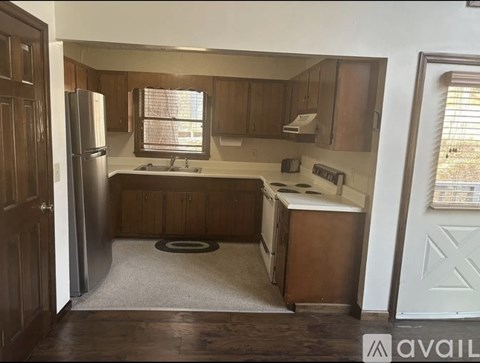 A kitchen with wooden cabinets and a white fridge.