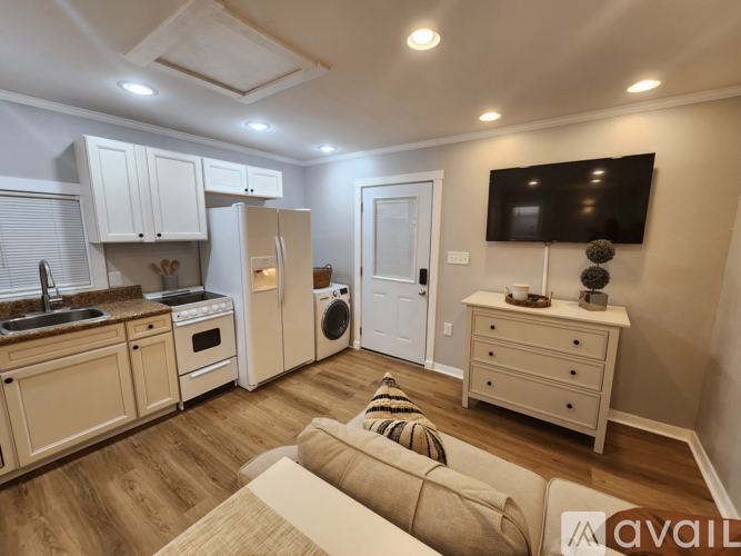 A kitchen with wooden floors and white cabinets.