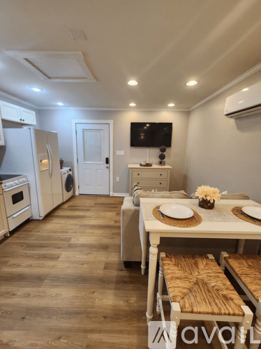 A kitchen with a table set for two with a vase of flowers on it.