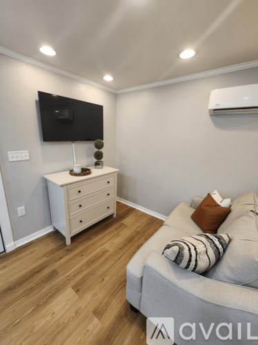 A living room with a grey couch and a white cabinet.
