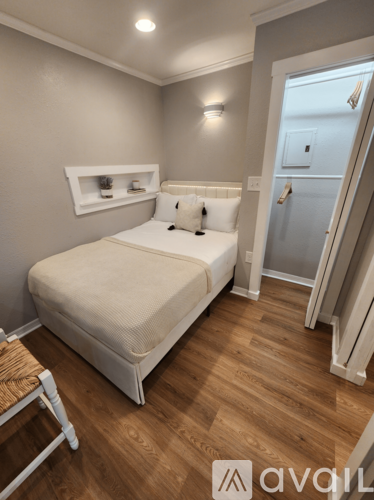 A bedroom with a bed, nightstand, and a chair.