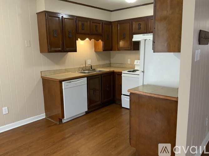 A kitchen with wooden cabinets and white appliances.