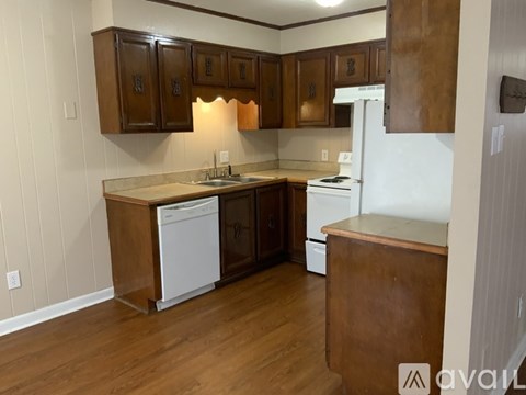 A kitchen with wooden cabinets and white appliances.