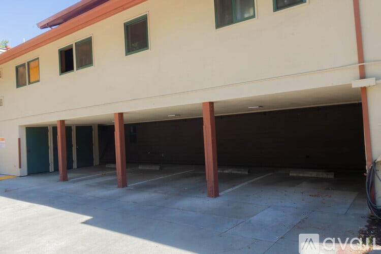 A large garage with a tan building and a red roof.