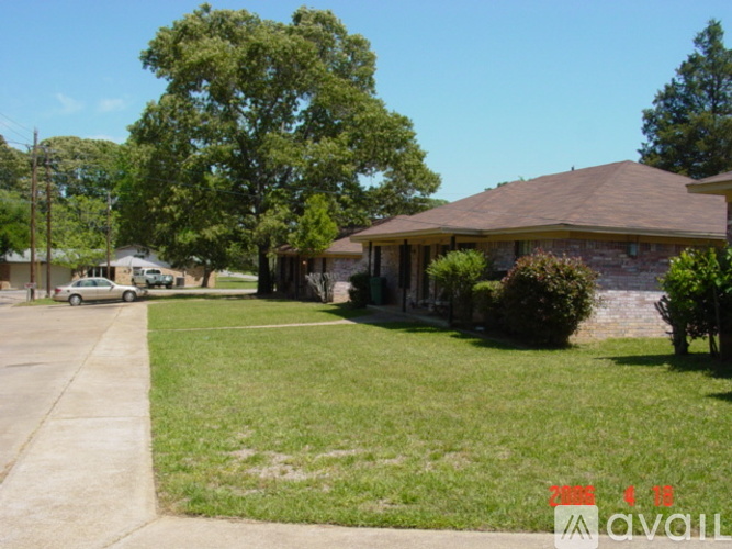 A house with a brown roof and a green lawn in front.