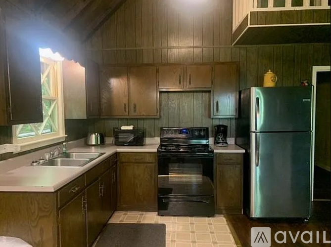 A kitchen with wooden cabinets and a stainless steel refrigerator.