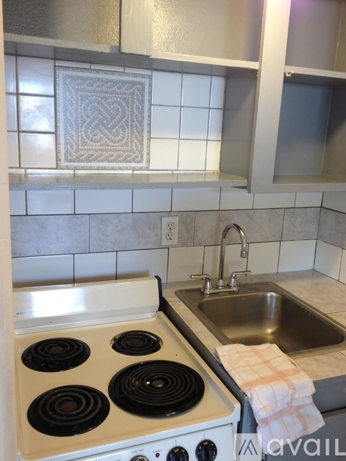 A kitchen with a stove top oven and a sink.