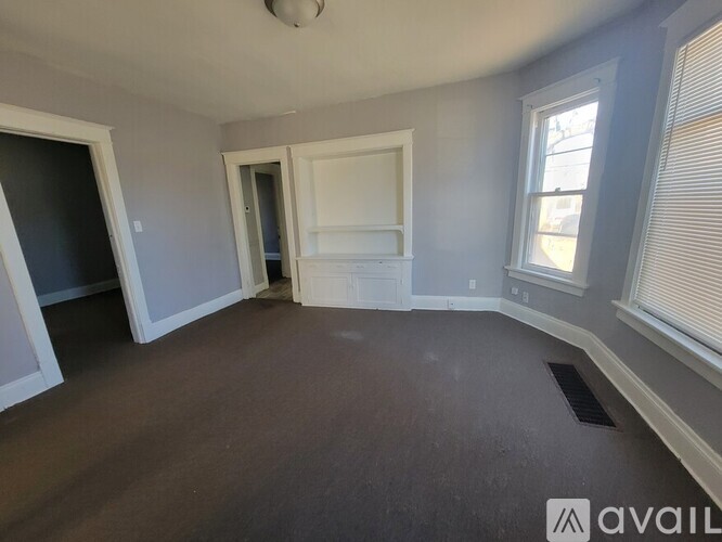 A room with a window and a door is available for rent.