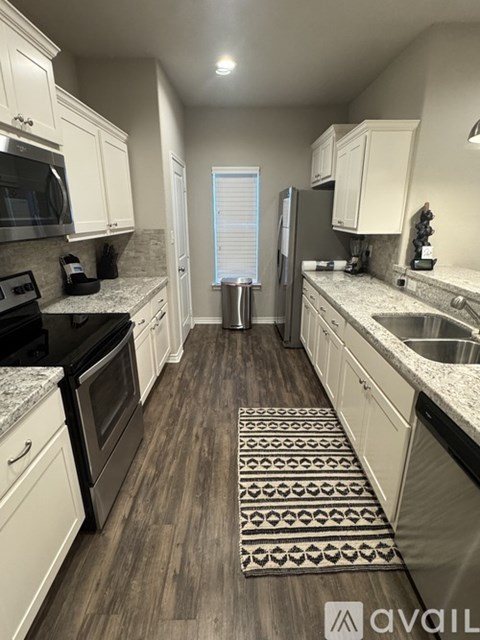 A kitchen with white cabinets and a black stove top oven.