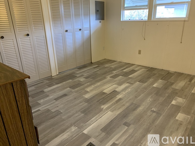 A room with wooden flooring and white walls.