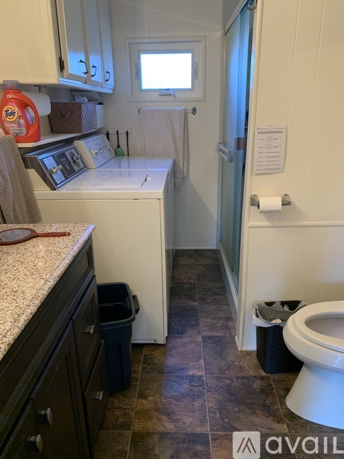 A small kitchen with a washing machine and a toilet.