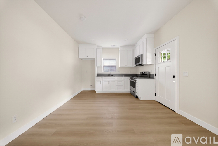 A spacious kitchen with white cabinets and appliances.