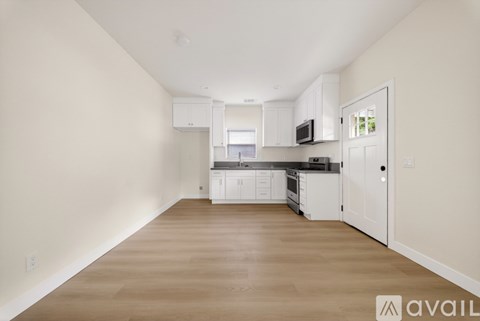 A spacious kitchen with white cabinets and appliances.