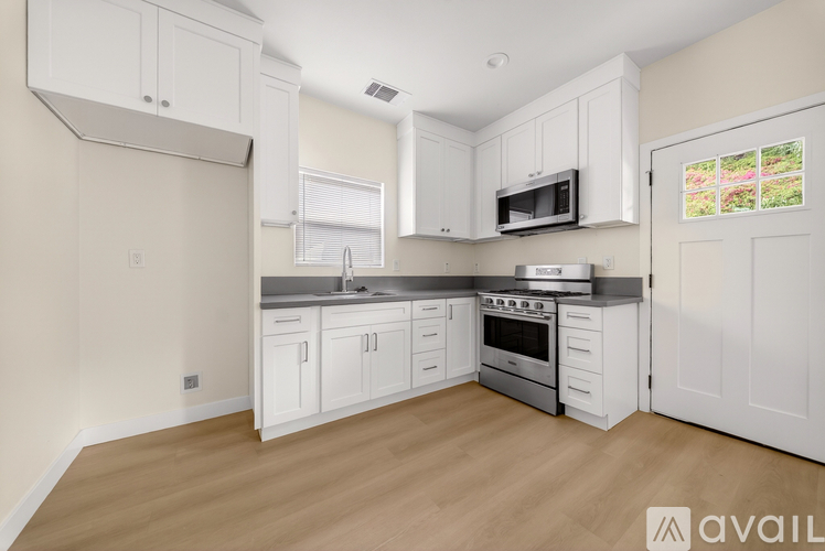A kitchen with white cabinets and a stainless steel oven.