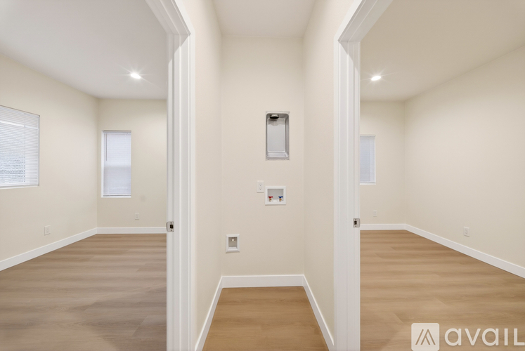 A spacious room with beige walls and flooring, and a white door on the right.