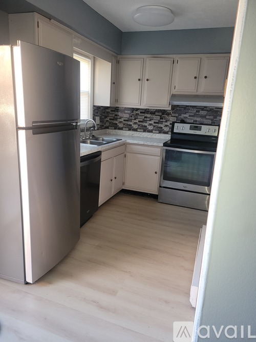 A kitchen with a refrigerator, sink, and oven.