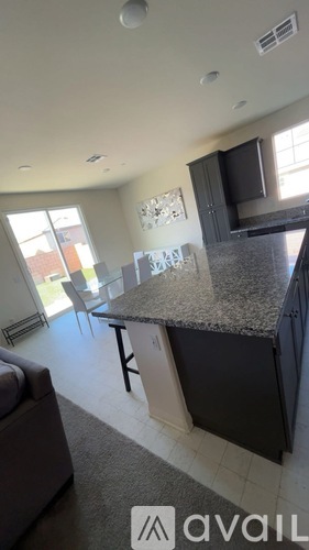 A kitchen with granite countertops and a large island.