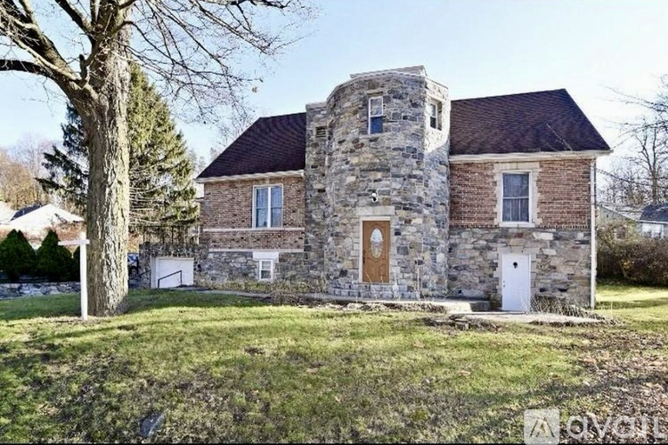 A stone house with a brown door and windows.