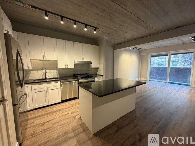 A modern kitchen with white cabinets and a black countertop.