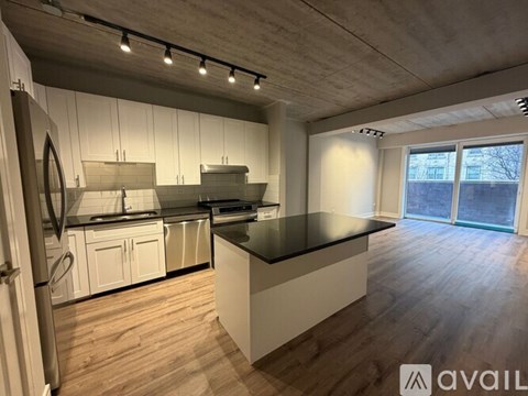 A modern kitchen with white cabinets and a black countertop.