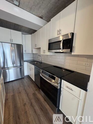 A floor plan of a 203 square foot apartment with one bedroom, one bathroom, a kitchen, a living room, and a balcony.