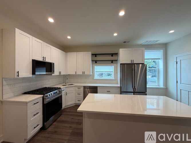A kitchen with wooden floors and a brick wall.