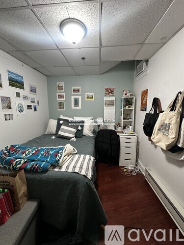 A bedroom with a bed, a dresser, and a wall with pictures and a sign that says "Dream Real Estates".