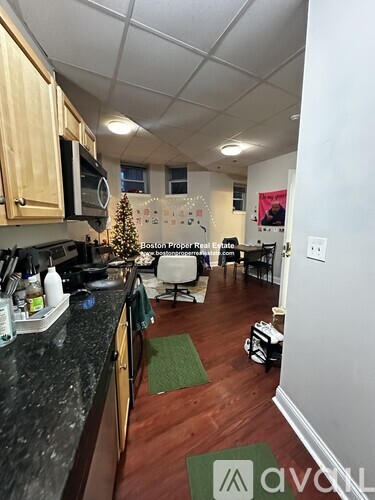 A kitchen with a black counter top and wooden cabinets.
