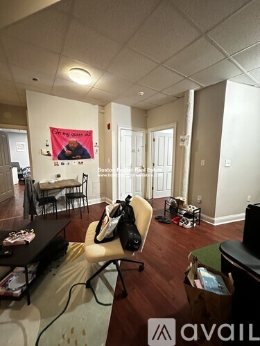 A living room with a couch, chair, and a poster on the wall.