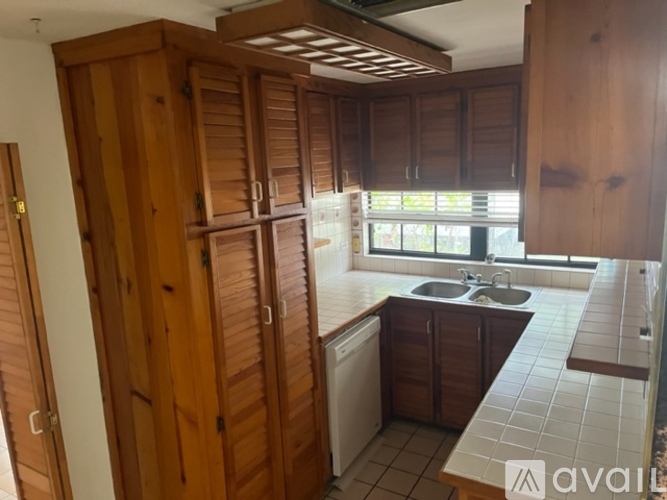 A kitchen with wooden cabinets and a white dishwasher.