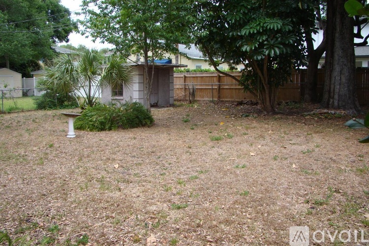 A backyard with a brown fence and trees.