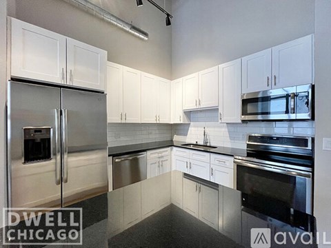 A kitchen with white cabinets and stainless steel appliances.