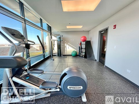 A gym with a treadmill, exercise balls, and a weight bench.