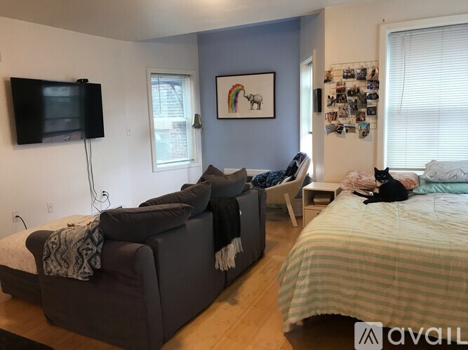 A bedroom with a bed, couch, and television.