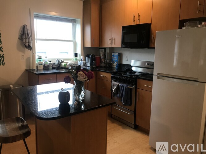 A kitchen with a black countertop and a white refrigerator.