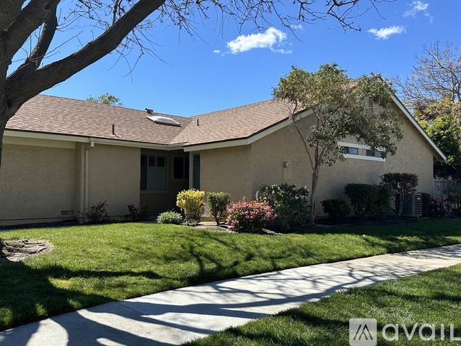 A house with a well-maintained lawn and a clear sky above.