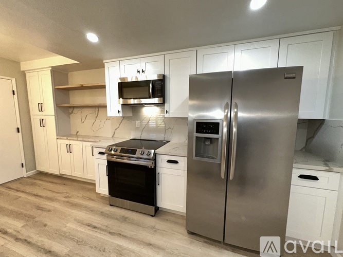 A modern kitchen with stainless steel appliances and white cabinets.