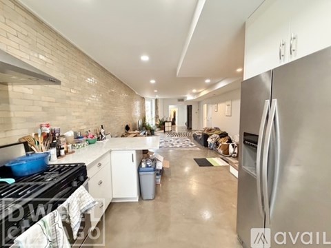 A kitchen with a stove, refrigerator, and a person in the background.