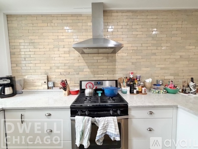 A kitchen with a stove top oven and a range hood above it.