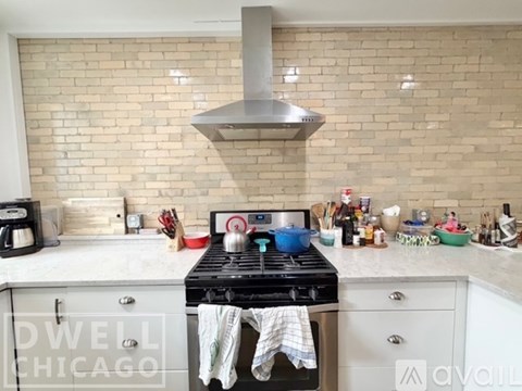 A kitchen with a stove top oven and a range hood above it.